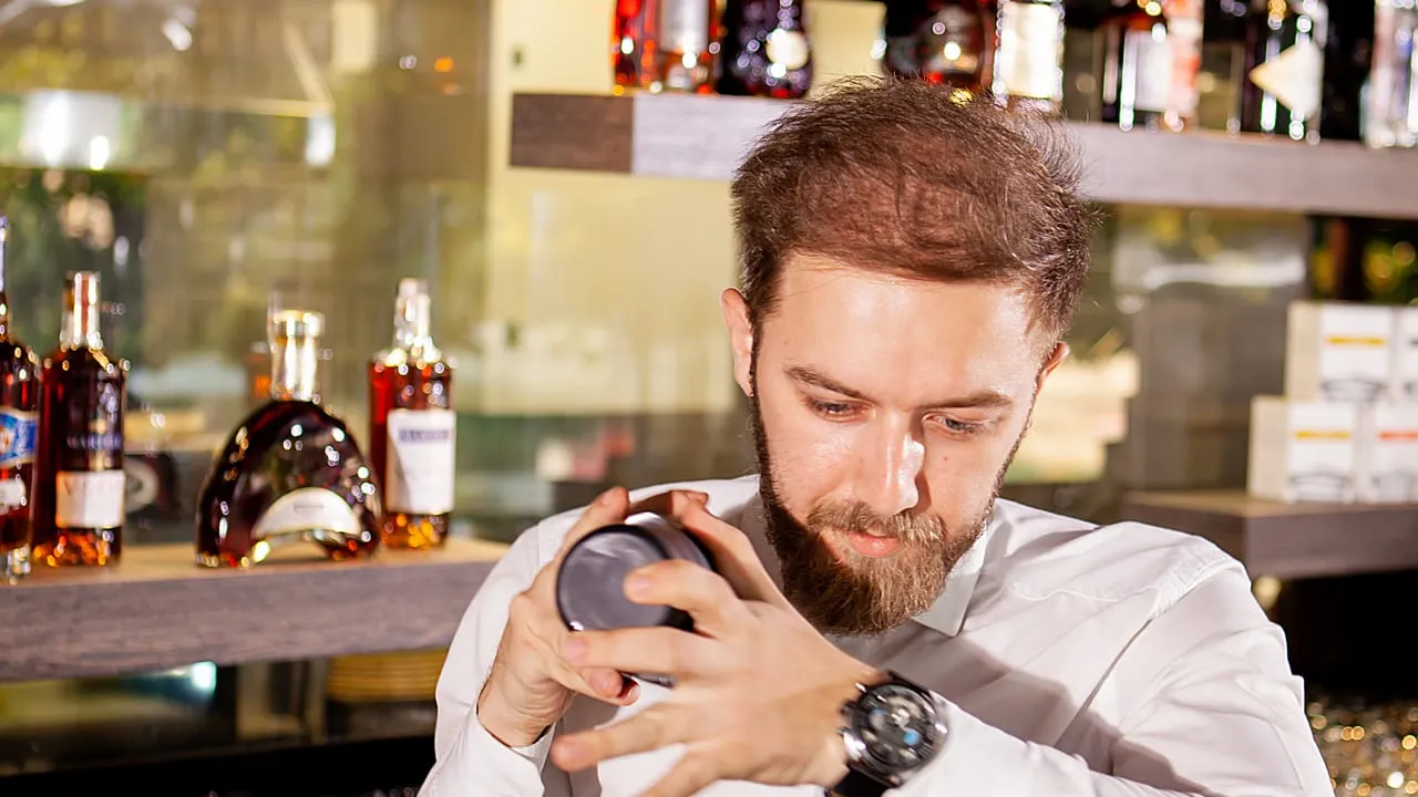Bartender preparando um drink no balcão do bar