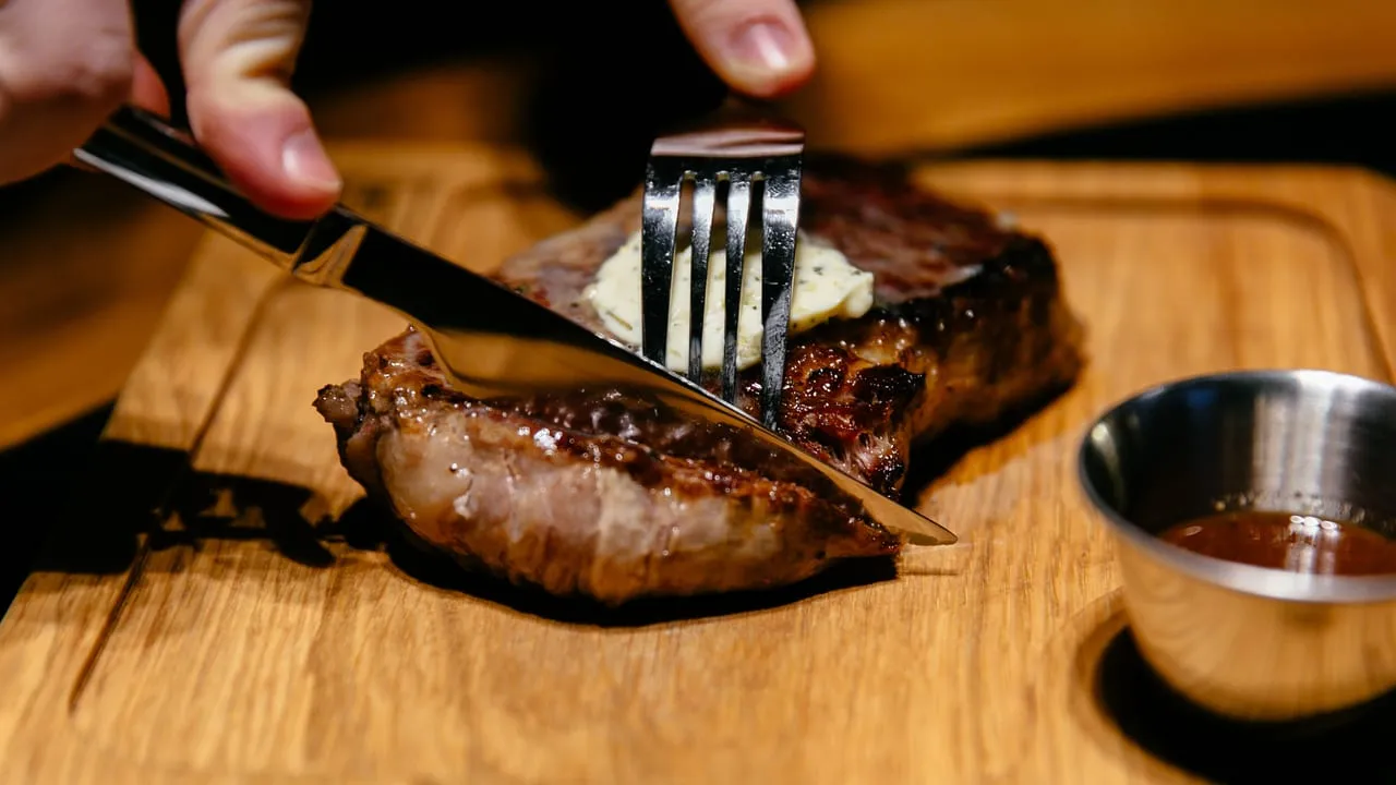 Corte de carne grelhada sendo fatiado na tábua