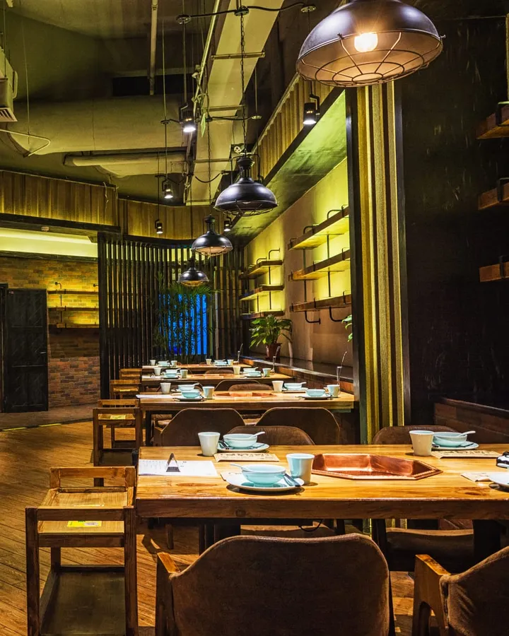 Salão de restaurante aconchegante com mesas de madeira e luz quente