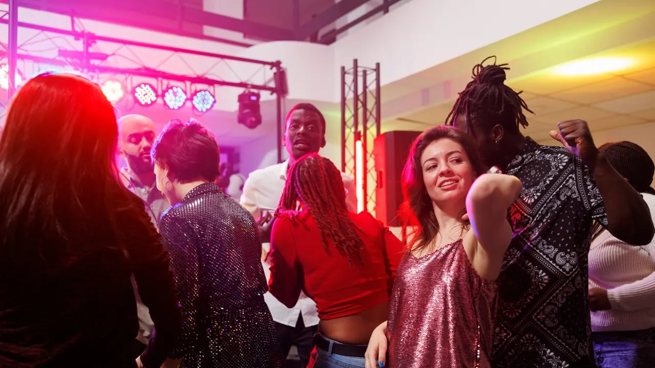 Pessoas dançando em balada com luzes coloridas